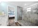 Bright bath with glass-enclosed shower and a glimpse into the main bedroom at 8704 Bay Crest Ln, Tampa, FL 33615