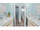 Dual sink bathroom with marble countertops, wood-look flooring, and walk-in shower at 8704 Bay Crest Ln, Tampa, FL 33615