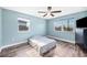Bright bedroom featuring a bed between two windows and a dresser against a blue wall at 8704 Bay Crest Ln, Tampa, FL 33615