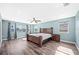 A spacious bedroom with wood floors, a ceiling fan, and ample natural light from large windows at 8704 Bay Crest Ln, Tampa, FL 33615