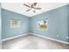 Empty bedroom featuring tile floors, ceiling fan, and two windows with neighborhood views at 8704 Bay Crest Ln, Tampa, FL 33615