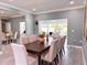 A modern dining area with tile floors, a large table and seating, and an open view to the backyard and pool at 8704 Bay Crest Ln, Tampa, FL 33615
