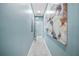 Long hallway with gray tile flooring, light blue walls, and a decorative painting at 8704 Bay Crest Ln, Tampa, FL 33615