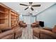 Spacious living room with wood floors, ceiling fans, built-in bookshelf, and comfortable leather seating at 8704 Bay Crest Ln, Tampa, FL 33615