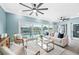 Bright living room with large windows overlooking the pool and waterway, light blue walls and ceiling fans at 8704 Bay Crest Ln, Tampa, FL 33615