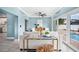 Open living room with modern furniture, tile flooring, light blue walls and direct access to the outdoor pool area at 8704 Bay Crest Ln, Tampa, FL 33615