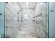Walk-in shower showcasing elegant marble tiling, glass enclosure, and custom shelving at 8704 Bay Crest Ln, Tampa, FL 33615
