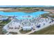 Aerial view of a community beach area, with lounge chairs, huts, beach, and lake at 10549 Torchwood Sea Way, San Antonio, FL 33576