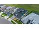 An aerial view of a home with an in-ground pool, a gray brick driveway, and dark shingle roof at 10549 Torchwood Sea Way, San Antonio, FL 33576
