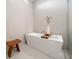 Bright bathroom showcasing a modern tub with clean lines, wood stool and minimalistic decor at 10549 Torchwood Sea Way, San Antonio, FL 33576
