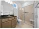 Bathroom featuring a vanity with granite countertop, toilet, and walk-in shower with glass doors at 10549 Torchwood Sea Way, San Antonio, FL 33576