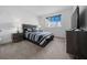 Cozy bedroom with a large window and side tables, featuring a sleek dark color palette at 10549 Torchwood Sea Way, San Antonio, FL 33576