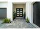 Inviting front entrance with a modern door, neat landscaping, and elegant hardscaping for a great first impression at 10549 Torchwood Sea Way, San Antonio, FL 33576