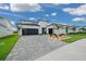 Beautiful home featuring a black garage door, a gray brick driveway, and well-maintained landscaping at 10549 Torchwood Sea Way, San Antonio, FL 33576