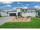 A modern home with a well-manicured lawn, dark garage door and minimalist landscaping for a stylish look at 10549 Torchwood Sea Way, San Antonio, FL 33576