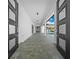 Hallway view featuring large windows leading to a pool area, providing an open and airy feel to the home at 10549 Torchwood Sea Way, San Antonio, FL 33576