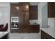 Modern kitchen featuring a built-in oven, dark wood cabinets, and sleek countertops at 10549 Torchwood Sea Way, San Antonio, FL 33576