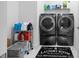 Efficient laundry room with a side-by-side washer and dryer set and storage shelves at 10549 Torchwood Sea Way, San Antonio, FL 33576