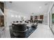 Bright living room featuring modern furniture, white walls, and sleek tile flooring, with a glimpse of the kitchen at 10549 Torchwood Sea Way, San Antonio, FL 33576
