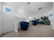 Bright seating area showcasing two blue swivel chairs, a glass table, and gray sectional couch at 10549 Torchwood Sea Way, San Antonio, FL 33576