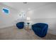 Cozy sitting area featuring two blue chairs, a round glass table, and three small windows at 10549 Torchwood Sea Way, San Antonio, FL 33576
