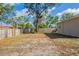 The backyard features a wooden fence, a large tree, and plenty of space at 2333 33Rd S St, St Petersburg, FL 33712