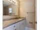 A bathroom features granite countertops and white cabinets, plus a tiled shower at 2333 33Rd S St, St Petersburg, FL 33712