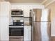 Modern kitchen with stainless steel appliances, including a refrigerator and stove, plus ample white cabinetry at 2333 33Rd S St, St Petersburg, FL 33712