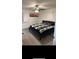 Cozy bedroom with sleek gray floors, ceiling fan and picture window with a view at 2902 Little Rd, Valrico, FL 33596