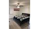 Cozy bedroom featuring a patterned blanket, ceiling fan, and natural light from the windows at 2902 Little Rd, Valrico, FL 33596