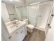 This bathroom features a glass-enclosed shower, vanity with sink, wood-look floors and chrome fixtures at 1424 Pine Glen Ln # D2, Tarpon Springs, FL 34688