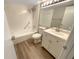A full bathroom features a tub with shower, laminate floor, and vanity with countertop sink at 1424 Pine Glen Ln # D2, Tarpon Springs, FL 34688