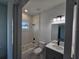 Bright bathroom features tub with tiled surround, gray vanity, and modern lighting at 2346 Logsdon St, North Port, FL 34287