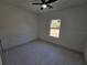 Simple bedroom with a ceiling fan and white tile floors at 2346 Logsdon St, North Port, FL 34287