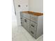 Modern gray bathroom vanity with black hardware and white marble-look tile floors at 24462 Cabana Rd, Punta Gorda, FL 33955
