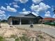 New construction home features a metal roof, gray stucco exterior, and a freshly poured concrete driveway at 24462 Cabana Rd, Punta Gorda, FL 33955