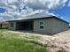 Gray stucco exterior with covered patio, and white trim windows overlooking the backyard at 24462 Cabana Rd, Punta Gorda, FL 33955