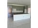 Spacious kitchen featuring gray cabinets, drawers and a white island with tile floor at 24462 Cabana Rd, Punta Gorda, FL 33955