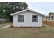 Exterior shot of house, showing the backyard with grass, mulch, and newly trimmed trees at 316 21St W St, Palmetto, FL 34221