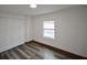 Bedroom with gray wood-style flooring, a double door closet, and a window at 316 21St W St, Palmetto, FL 34221