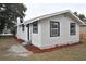 Side view of freshly painted white house with manicured landscaping and updated windows at 316 21St W St, Palmetto, FL 34221