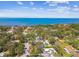 Captivating aerial shot of a home featuring a sparkling pool, surrounded by trees, with a scenic ocean view at 913 Tennessee Ln, Sarasota, FL 34234