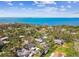 Breathtaking aerial view showcasing a beautiful home with a private pool, lush greenery, and stunning waterfront backdrop at 913 Tennessee Ln, Sarasota, FL 34234