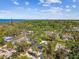 An aerial view of a coastal neighborhood featuring lush trees, well-maintained homes, and water in the distance at 913 Tennessee Ln, Sarasota, FL 34234
