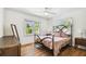 Bright bedroom featuring a ceiling fan, wood floors, and two windows that provide ample natural light at 913 Tennessee Ln, Sarasota, FL 34234