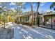Side view of a white home showing a driveway, gate, and lush landscaping at 913 Tennessee Ln, Sarasota, FL 34234