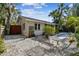 Charming home with metal bench and table, surrounded by white gravel and lush landscaping at 913 Tennessee Ln, Sarasota, FL 34234