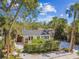 Well-kept single-story home with a manicured hedge, a gated driveway, and tropical landscaping at 913 Tennessee Ln, Sarasota, FL 34234