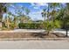 A charming home partially obscured by a green hedge and verdant trees at 913 Tennessee Ln, Sarasota, FL 34234