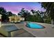 Inviting backyard with a sparkling pool, sunroom, outdoor dining area, and lush tropical landscaping at 913 Tennessee Ln, Sarasota, FL 34234